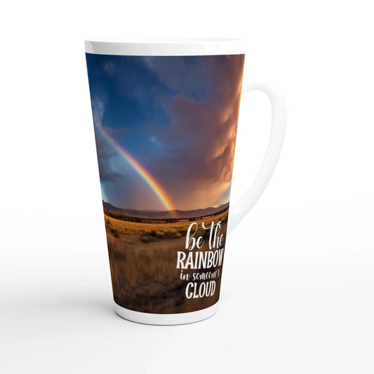 Weiße Jumbotasse mit Druck einer Landschaft unter Wolken im Sonnenuntergang mit einem wunderschönen Regenbogen. Darunter der Schriftzug "be the rainbow in someones cloud"
